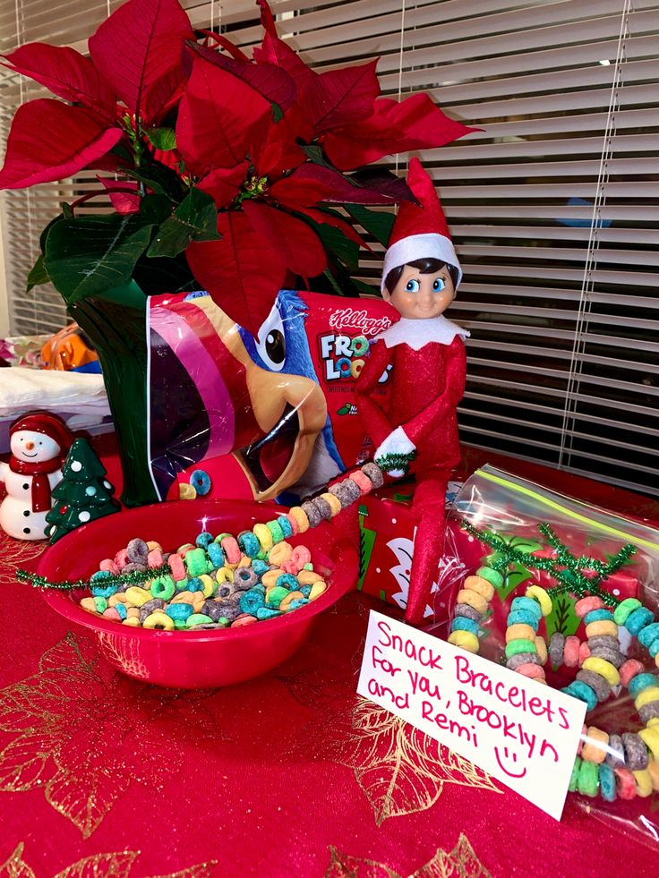 an elf is sitting next to a bowl of candy