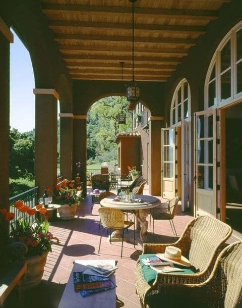 an outdoor covered patio with wicker furniture