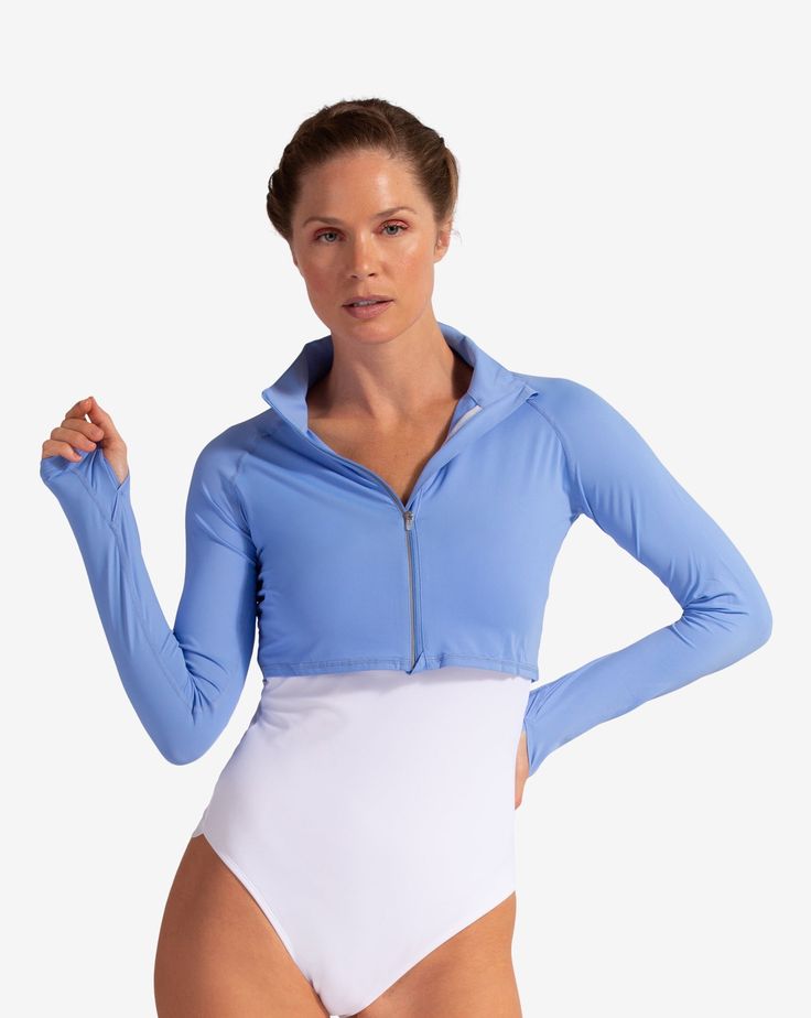 Women wearing indigo full zip crop top over white swimsuit. (Style 4010) - BloqUV Spring Half-zip Stretch Activewear, Stretch Half-zip Spring Activewear, Stretch Half-zip Activewear For Spring, Spring Stretch Half-zip Activewear, Fitted White Tops With Uv Protection, Fitted White Top With Uv Protection, Fitted Upf 50+ Tops For Outdoor, Fitted Track Jacket With Zipper Closure For Outdoor, Fitted Track Jacket With Zipper For Outdoor