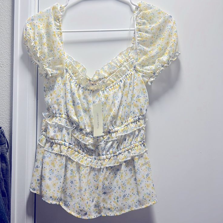 Medium Sized Blouse From Francesca’s. White With Blue, Yellow And Green Floral Pattern. New With Tags, Originally $34. Feminine Yellow V-neck Blouse, Yellow Feminine Blouse, Yellow Feminine Blouse For Daywear, Feminine Yellow Blouse For Daywear, Feminine Yellow Floral Print Tops, Feminine Fitted Yellow Blouse, Feminine Yellow Blouse For Brunch, Yellow Ruffled Top For Brunch, Feminine Fitted Yellow Tops