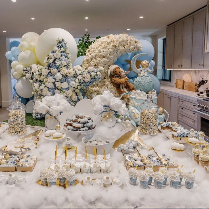 a table filled with lots of desserts and balloons