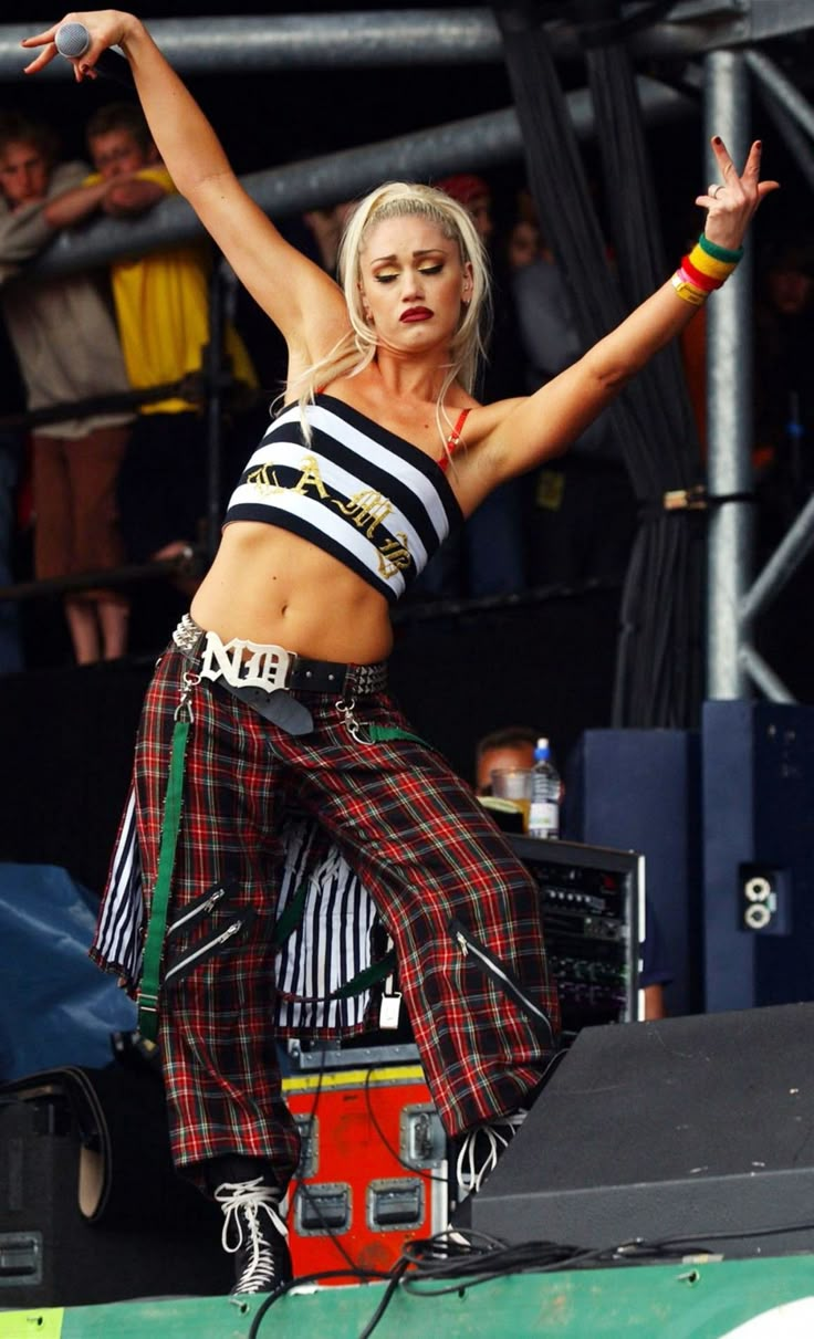 a woman in plaid pants is performing on stage