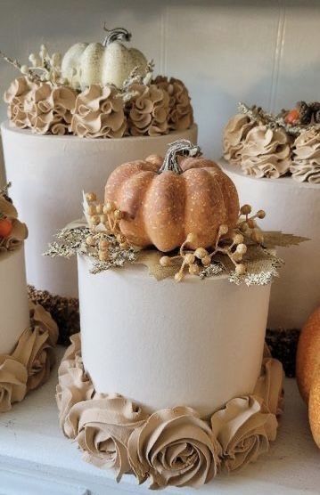 there are many cakes decorated with pumpkins and flowers on the top one is white