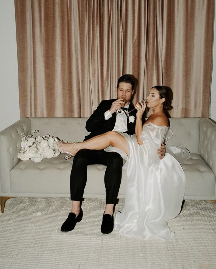 a bride and groom sitting on a couch