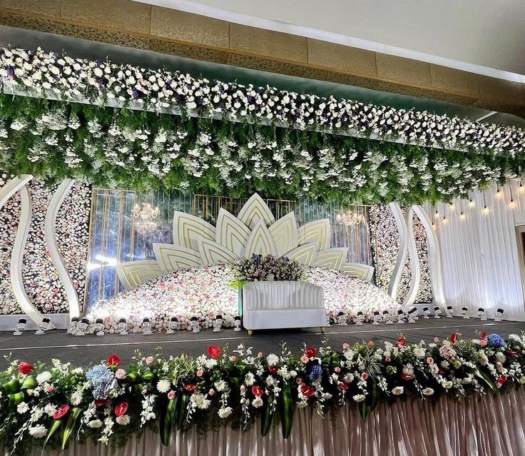 an elaborate stage decorated with flowers and greenery