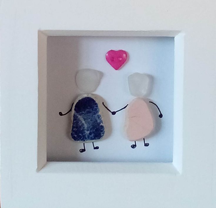 two people holding hands in a shadow box with a pink heart on the other side