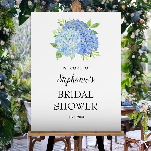 a welcome sign for a bridal shower with hydrangeas and greenery in the background