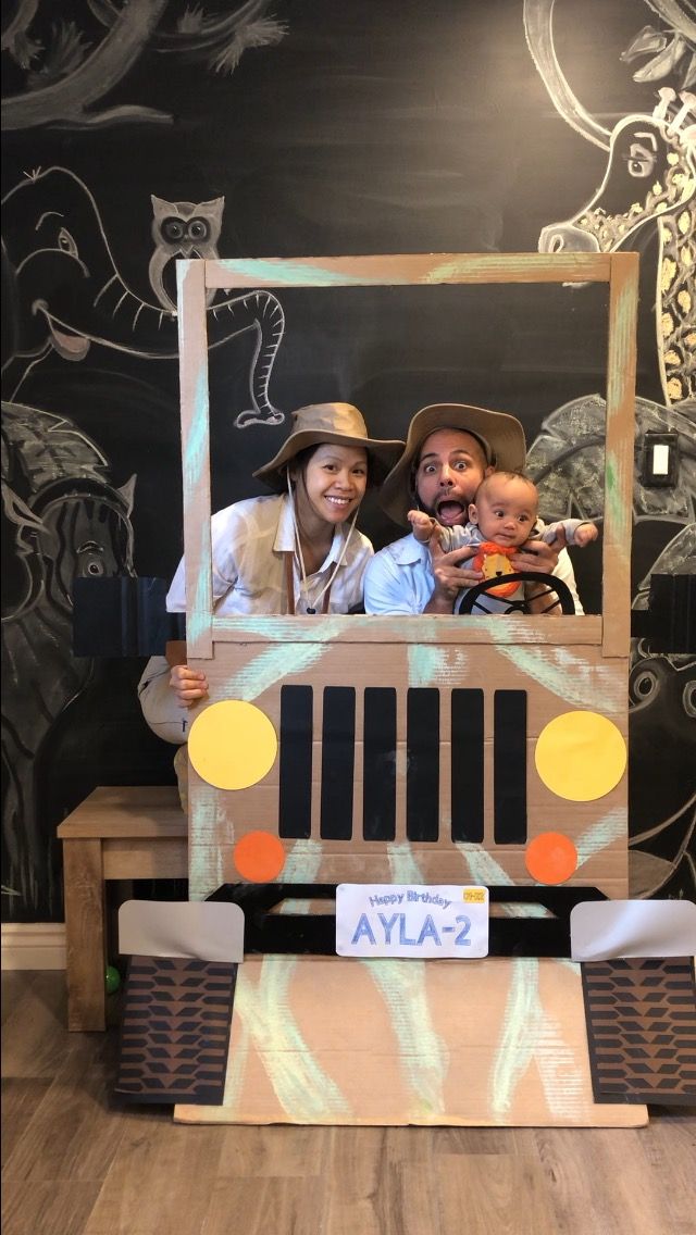 two people standing in front of a fake jeep with an animal theme on the side