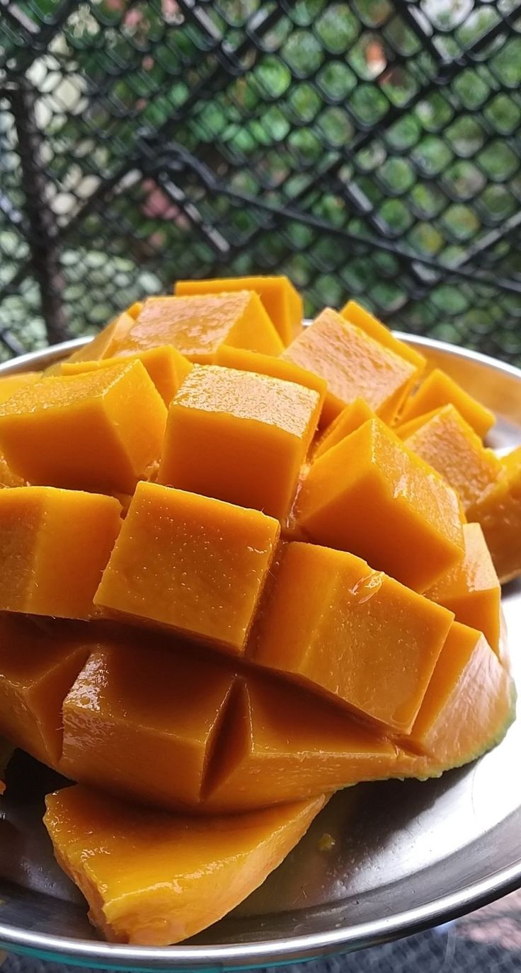 a metal plate topped with cut up pieces of mango