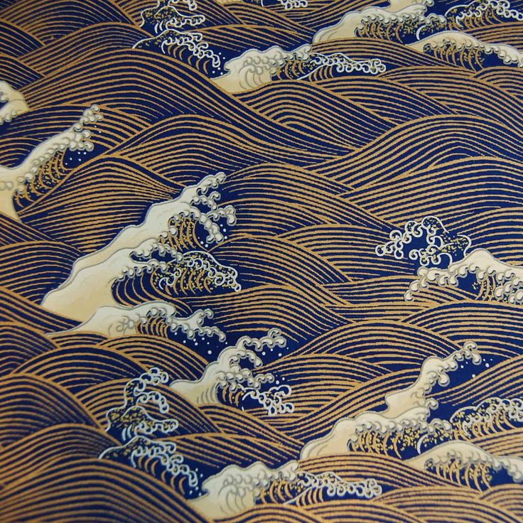 an image of waves in the ocean that is blue and gold with white designs on it