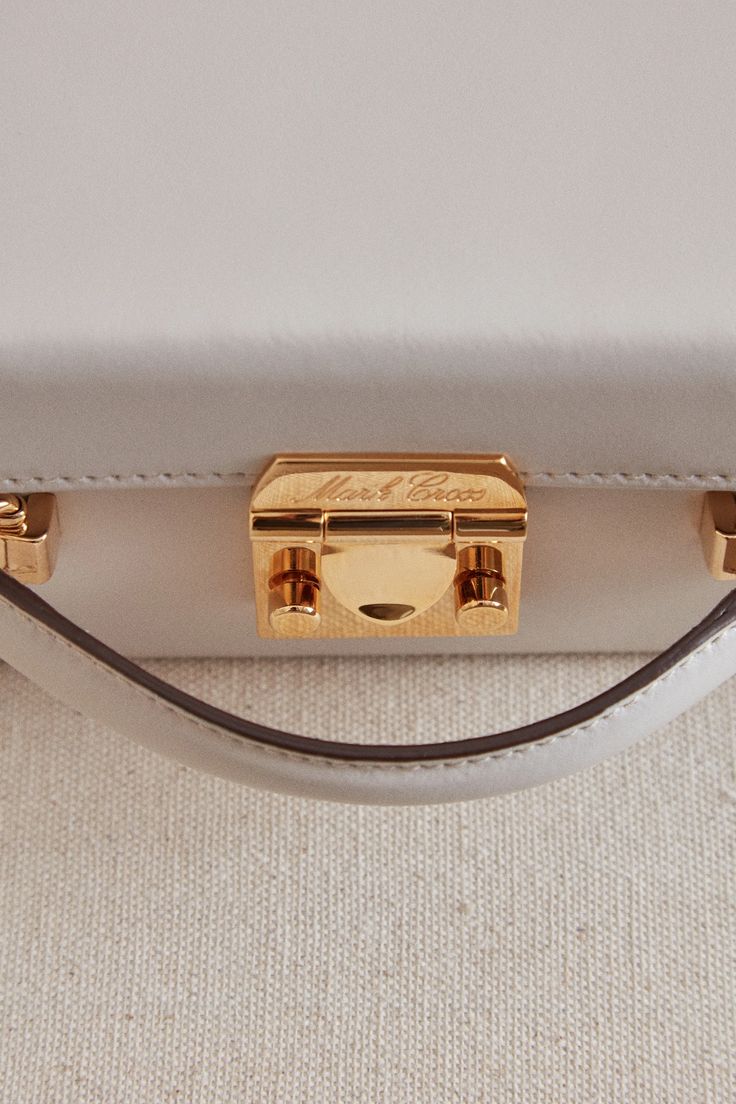 The Grace Box has been a signature Mark Cross style since the 1950’s. The structured square shape was inspired by an overnight case created by the brand for Grace Kelly in the film “Rear Window", and the iconic push-lock closure originates from Mark Cross trunks in the late 1800s. Now reimagined in Light Taupe calfskin leather, the Grace Box offers versatility via both a top handle and shoulder strap. Length: 19.1 cm / 7.5” Height: 14 cm / 5.5” Width: 8.9 cm / 3.5” Strap drop: 50.8 cm / 20" Hand Classic Box Bag With Palladium Hardware, Classic Square Box Bag With Gold-tone Hardware, Elegant Everyday Luxury Rectangular Box Bag, Classic Rectangular Box Bag With Palladium Hardware, Classic Rectangular Box Bag With Original Box, Timeless Rectangular Box Bag For Formal Occasions, Elegant Rectangular Box Bag With Palladium Hardware, Classic Rectangular Box Bag, Classic Gold Box Bag For Formal Occasions