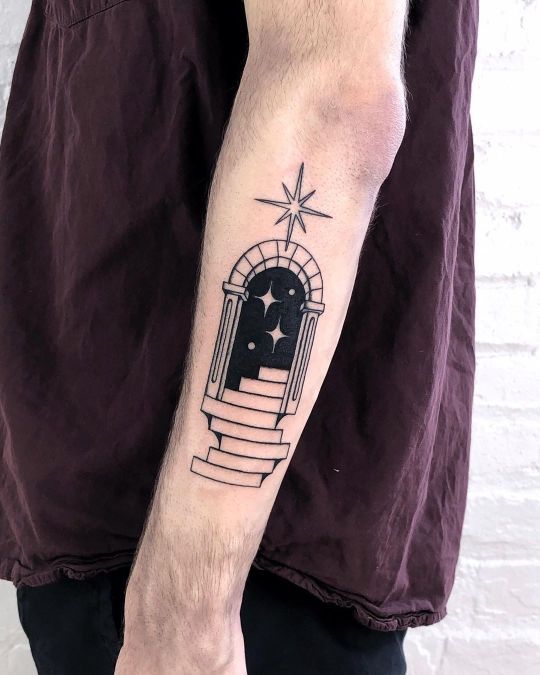 a man's arm with a tattoo on it that has an image of a window and stars