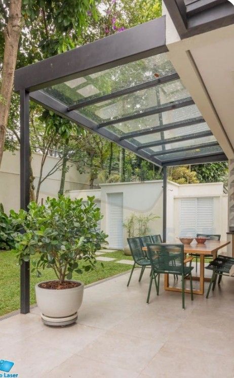 an outdoor dining area with table, chairs and potted plant in the middle of it