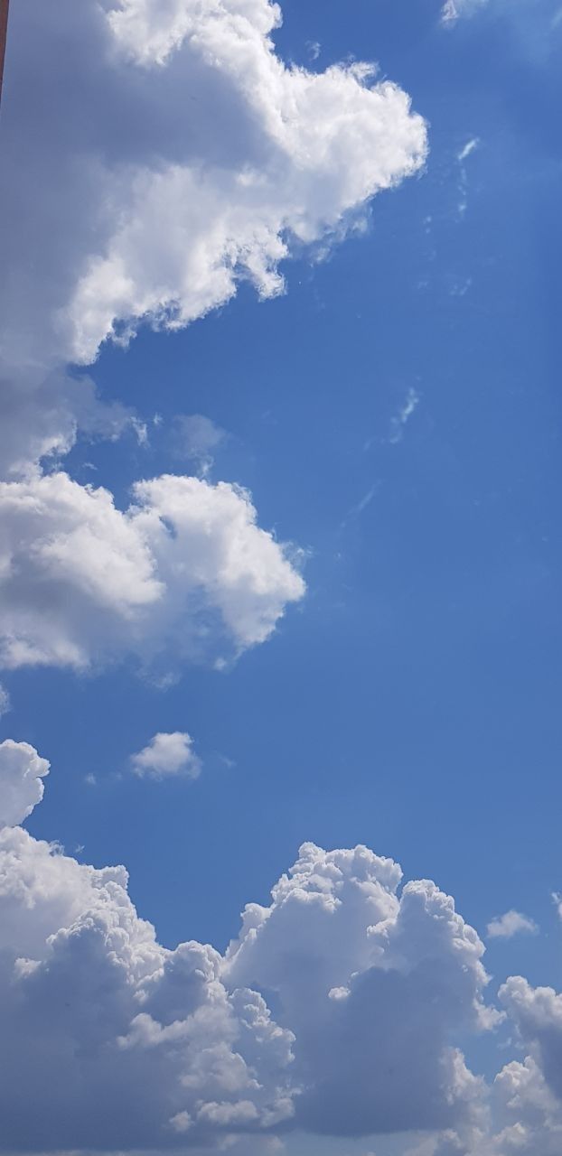 an airplane is flying high in the blue sky with white clouds above it and below