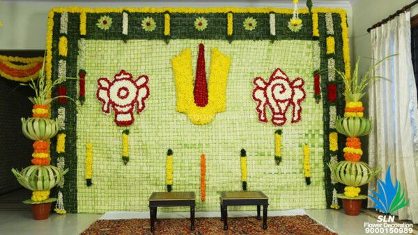 a room decorated with flowers and decorations on the wall, along with two benches in front of it