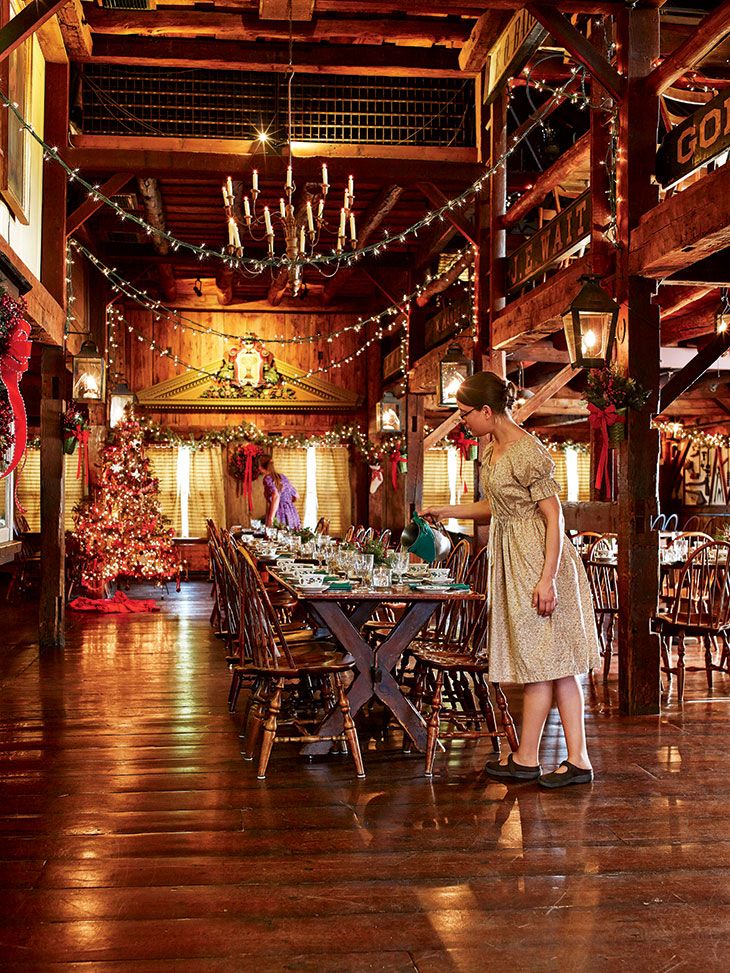 a woman is standing in the middle of a large room with christmas decorations on the walls