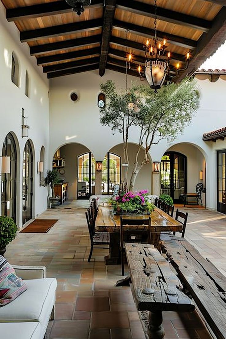 an outdoor dining area with wooden benches and potted plants on the table in front of it