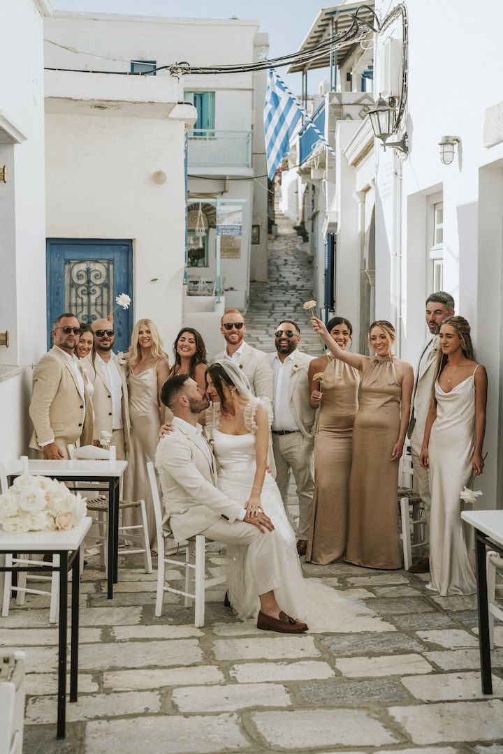 a group of people standing around each other in front of a building with white walls