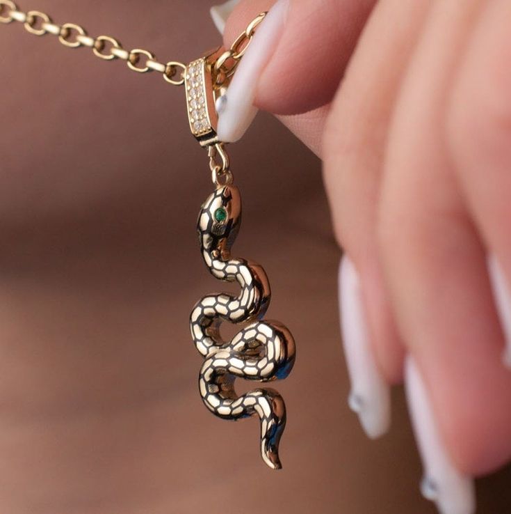 Our snake pendant necklace is made of 14k solid gold. It has an absolutely unique style that everyone loves it!  Our snake is decorated with black enamel art to look like snakeskin. Its eyes consist of charming green zircon stones and its clip is decorated with white zircon stones. The best thing about our unique snake pendant is it is suitable for most chains. You can use it with most of the chains or you can attach it to your bracelet. Because the clip of the snake pendant necklace can be open Unique Snake Shape Necklace For Gift, Gift Jewelry With Curb And Snake Chain, Symbolic Snake Shaped Necklace For Gift, Symbolic Snake-shaped Necklace For Gift, Symbolic Snake Necklace As A Gift, Unique Black Snake-shaped Jewelry, Black Snake Necklace For Gift, Black Snake Necklace For Gifts, Black Snake Shape Necklace For Gift