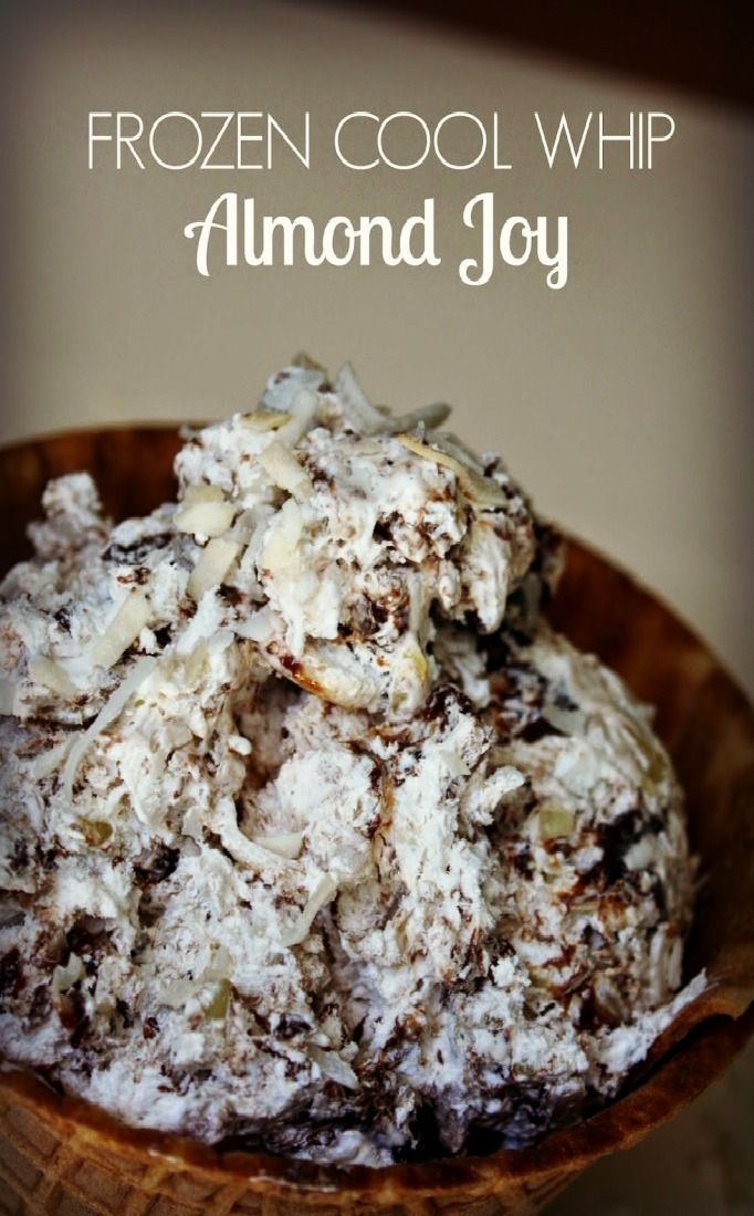 a wooden bowl filled with ice cream and nuts