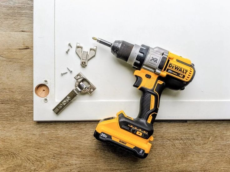 a cordless drill and screwdriver sitting on top of a piece of paper