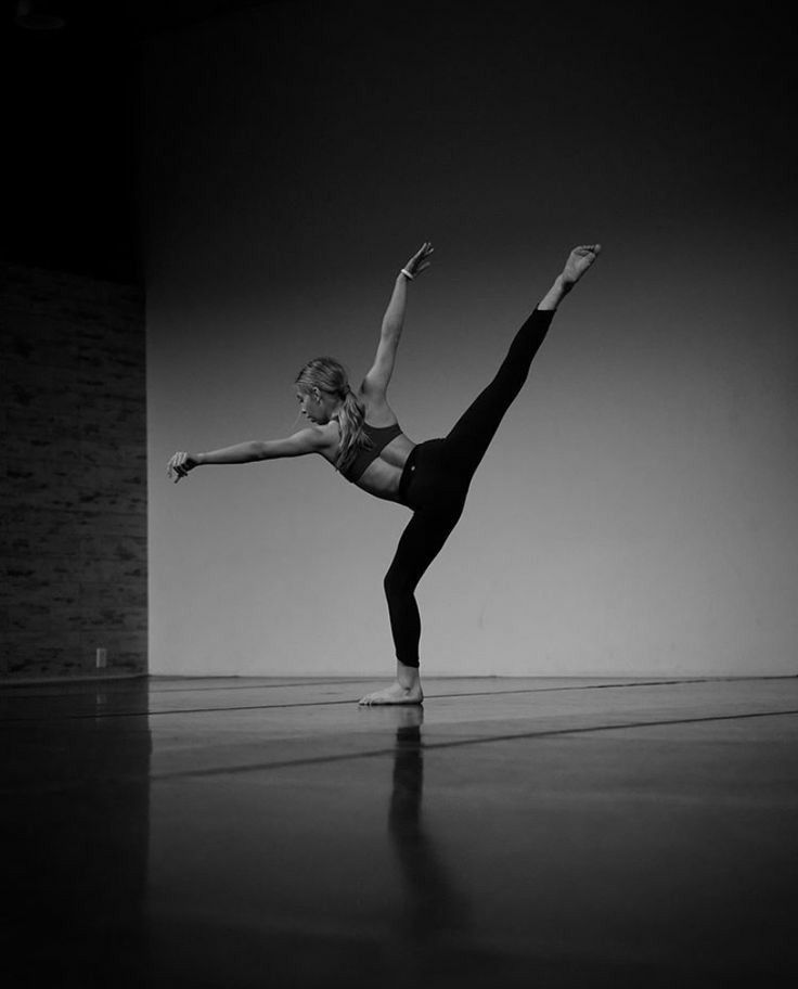 a woman in black and white doing a dance pose