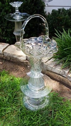 a glass water fountain sitting in the grass