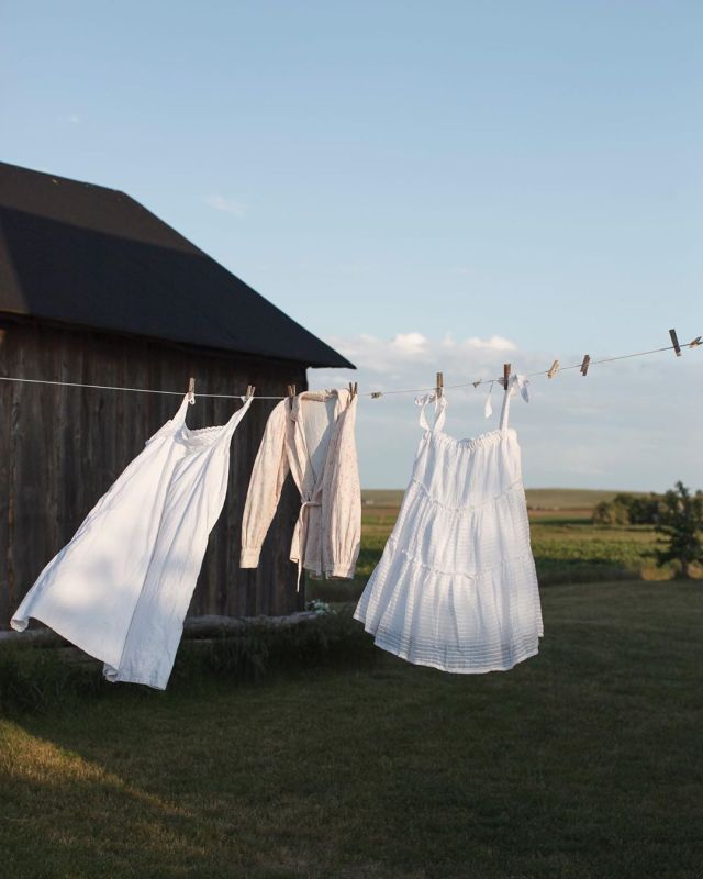 clothes hanging out to dry in front of a barn