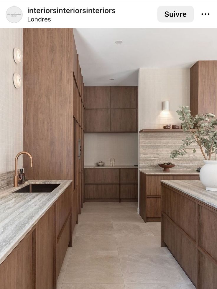 a large kitchen with wooden cabinets and marble counter tops is featured on the instagram