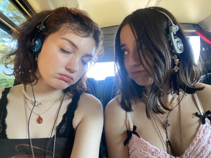 two young women sitting in the back of a car