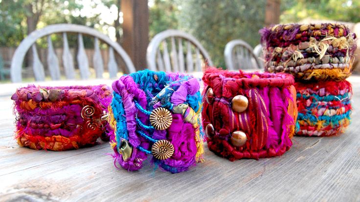 four different colored bracelets sitting on top of a wooden table