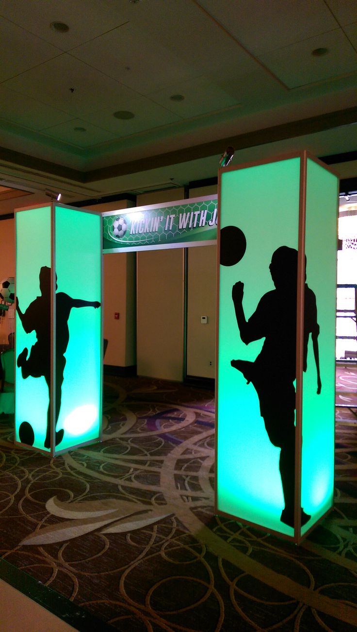 the silhouettes of people are projected on three separate screens in an indoor area with carpeting