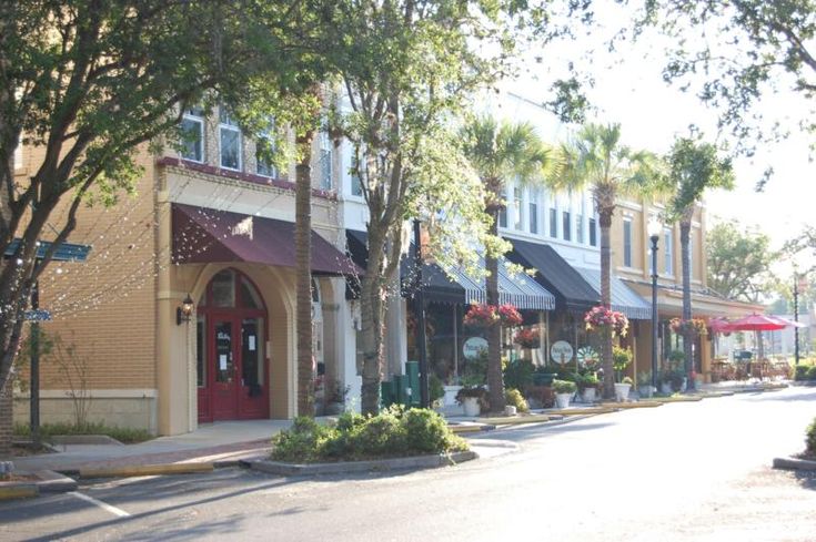 an empty street lined with shops and trees