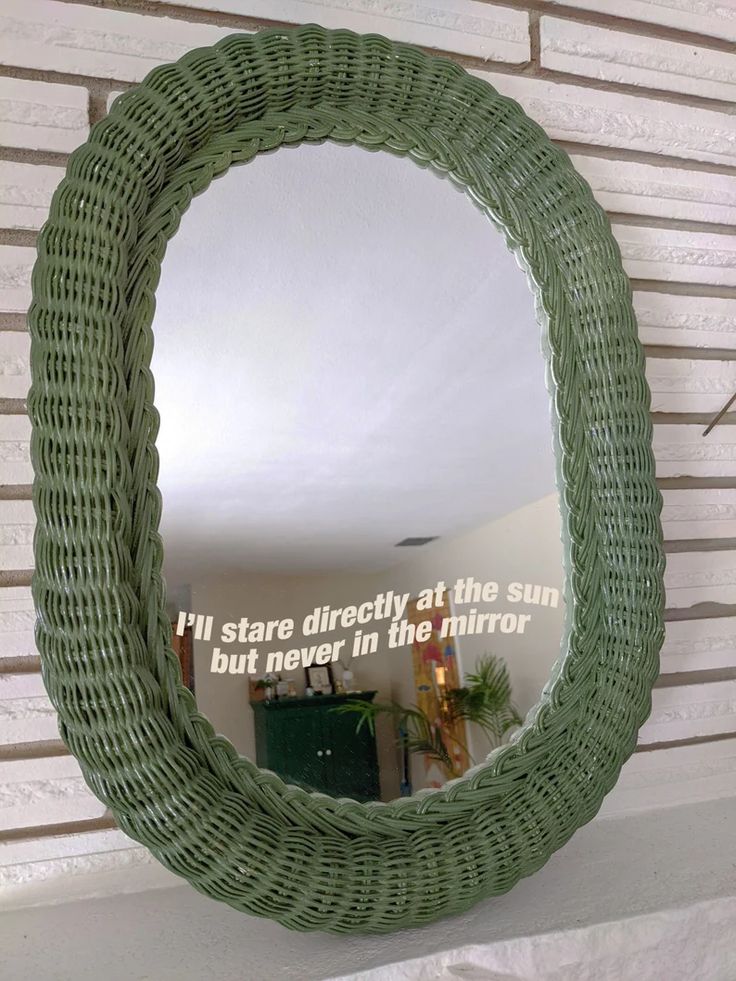 a round mirror hanging on the side of a wall