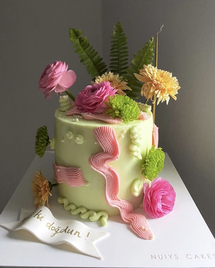 a cake decorated with flowers and leaves on a table