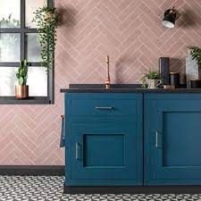 a bathroom with pink walls and blue cabinets