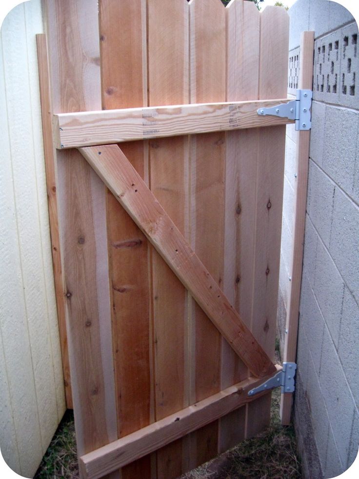 a wooden gate is being built into the side of a building