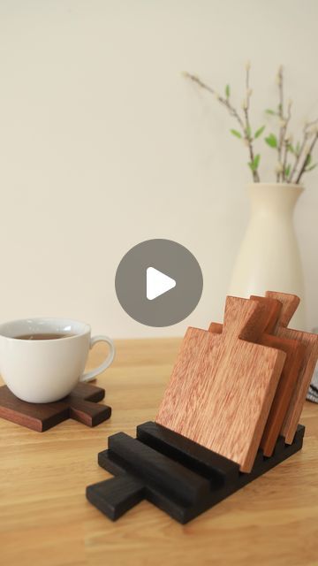 a cup of coffee sitting on top of a table next to a wooden cutting board