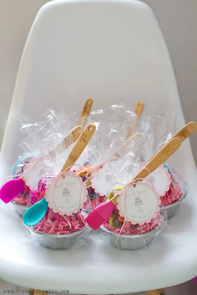 plastic cups filled with pink and blue candies on top of a white chair in a room