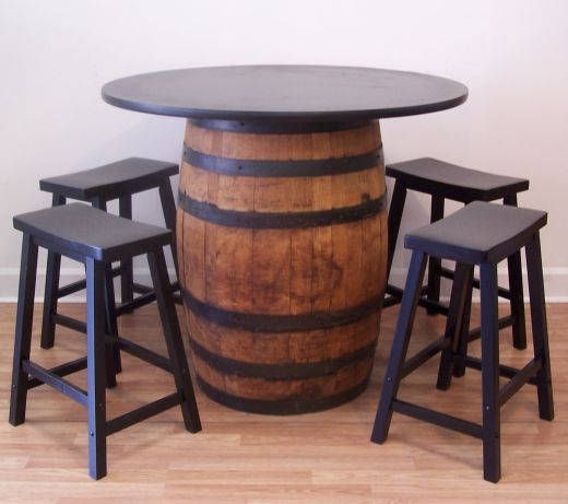 a table with stools around it and a wine barrel on the floor next to it