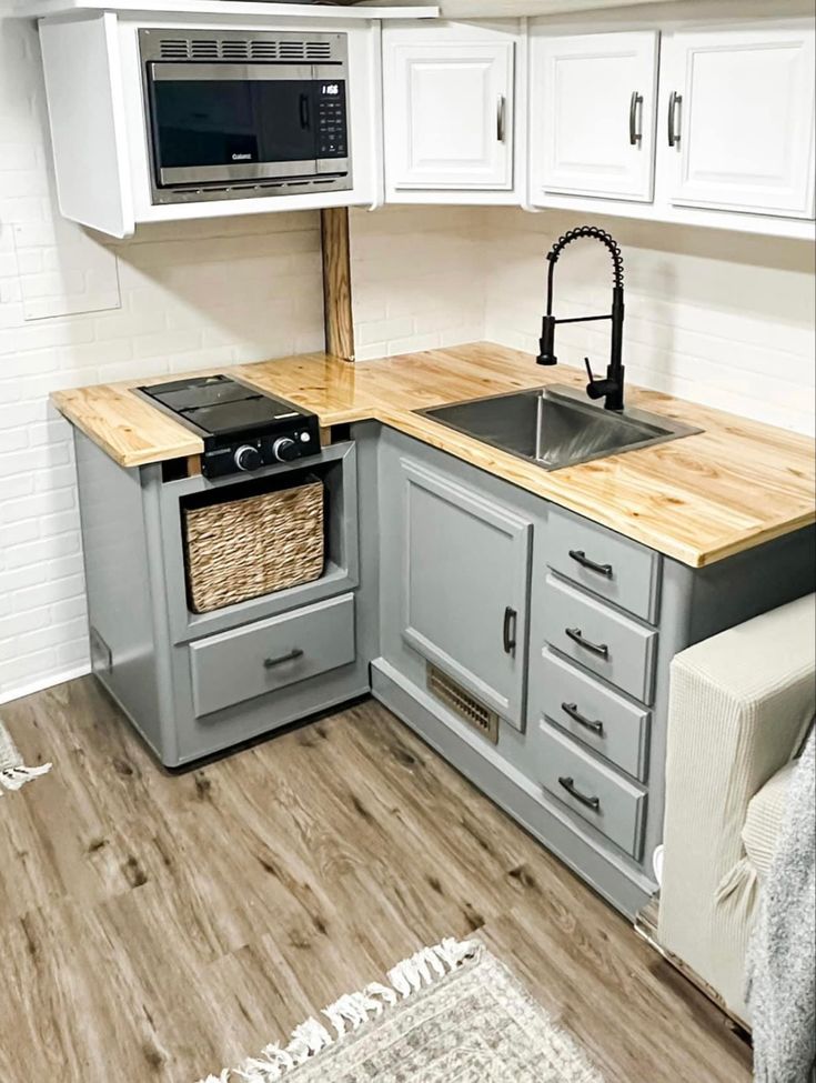 a kitchen with an oven, sink and microwave above the countertop is shown in this image