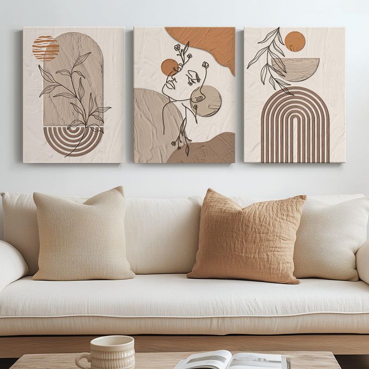 three abstract paintings hang on the wall above a white couch in a modern living room