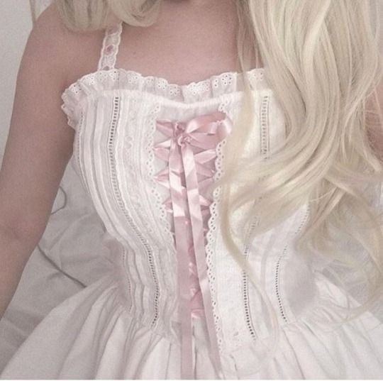 a woman with long blonde hair wearing a white dress