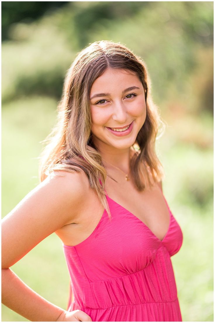 a beautiful young woman in a pink dress posing for a photo