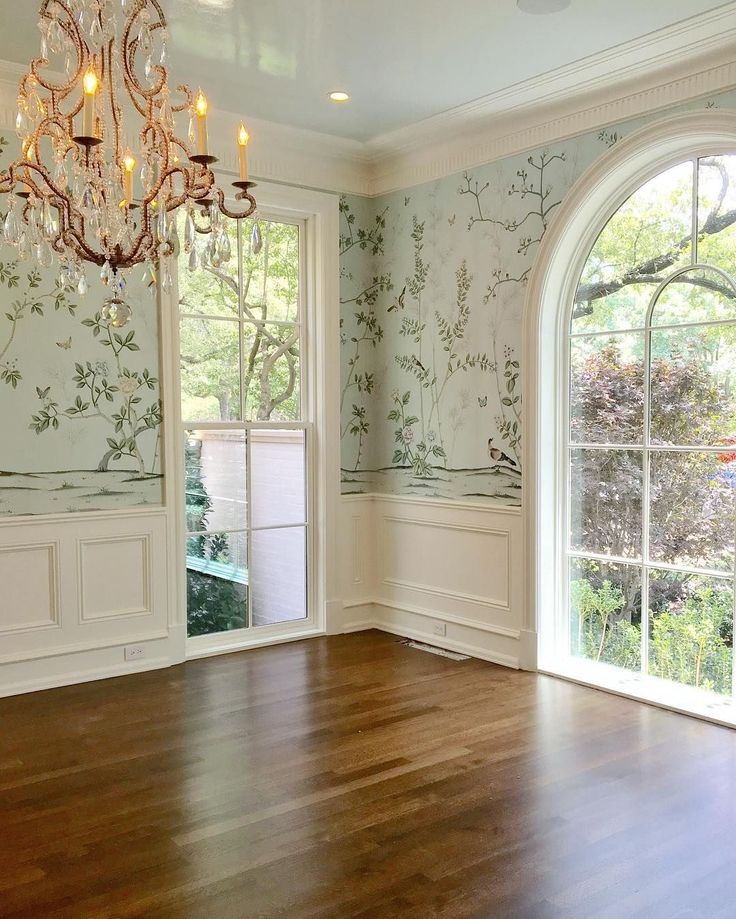 an empty room with wood floors and chandelier