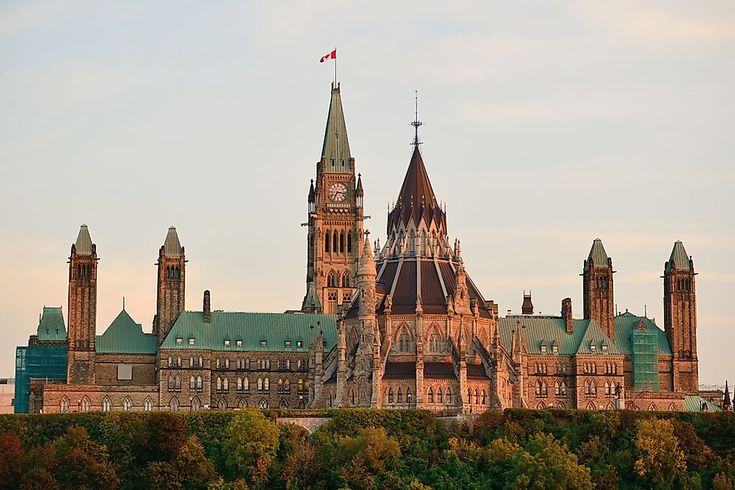 a large building with towers and spires on top of it's roof, surrounded by trees