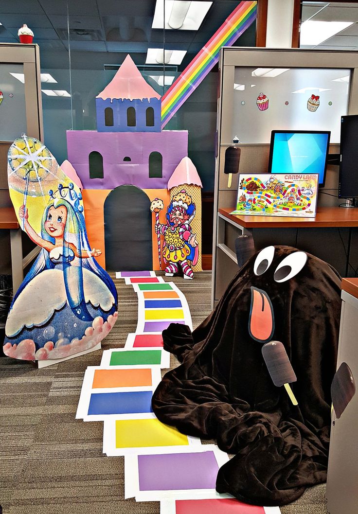 an office cubicle decorated with paper cut outs and colorful carpeting, featuring cartoon characters