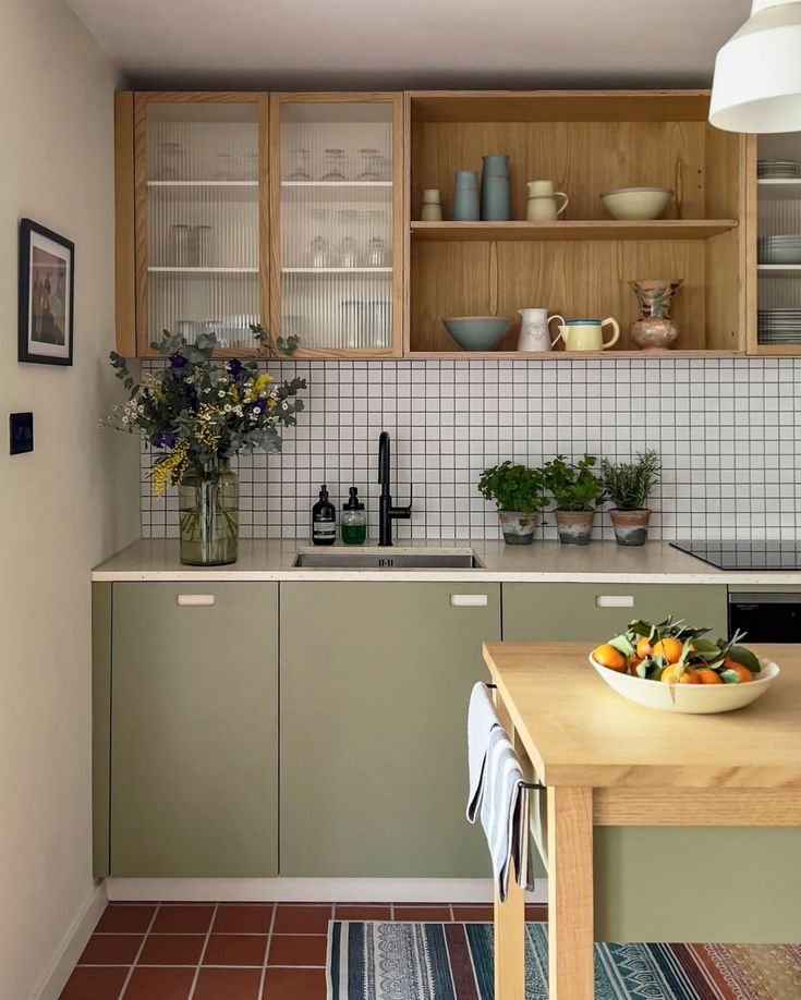 a bowl of fruit is sitting on the counter top in this modern kitchen with tile flooring