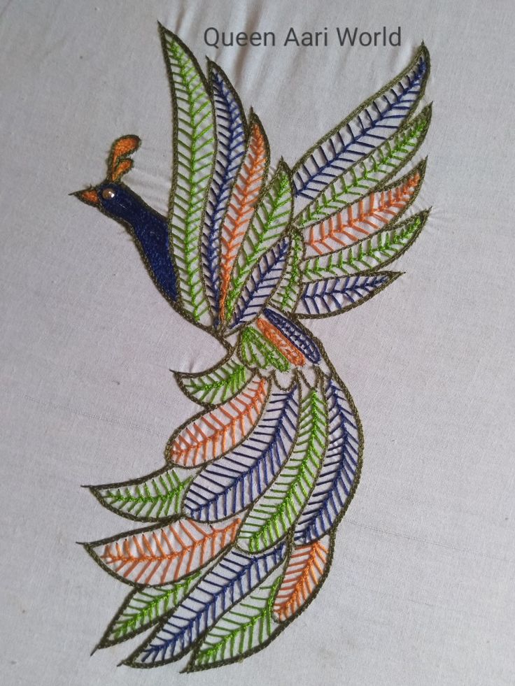 an embroidered bird on a white cloth with green and orange leaves in the center,