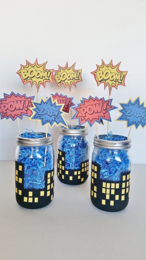 three jars filled with blue and yellow confetti on top of a white table